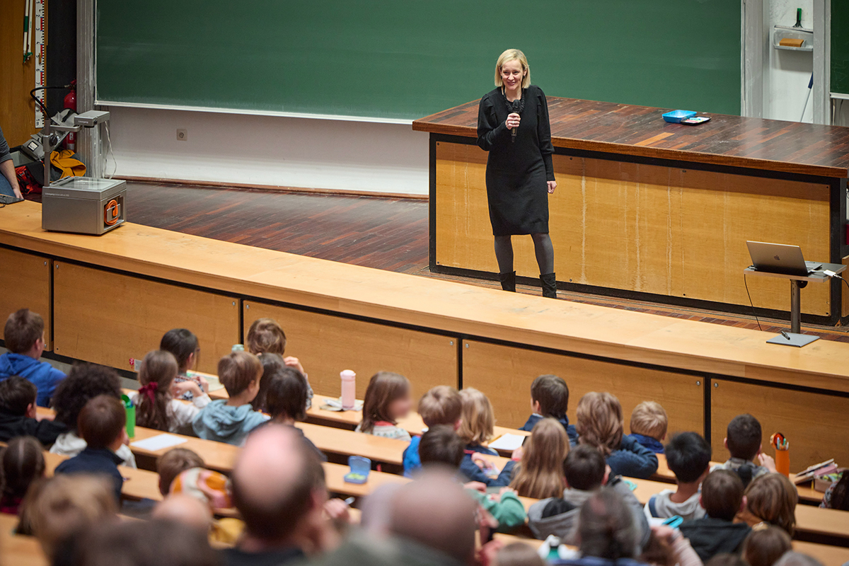 Frau Prof. Dr. Specht-Riemenschneider steht mit Mikrofon auf der Uni Bühne (Quelle: Volker Lannert, Universität Bonn) Frau Prof. Dr. Specht-Riemenschneider steht mit Mikrofon auf der Uni Bühne