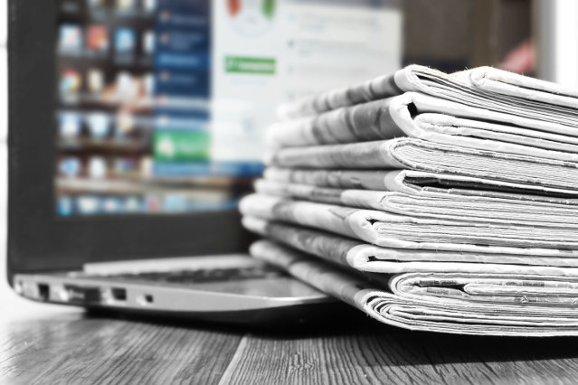 es sind Zeitungen und ein Laptop abgebildet (Quelle: ©photokozyr - stock.adobe.com) es sind Zeitungen und ein Laptop abgebildet
