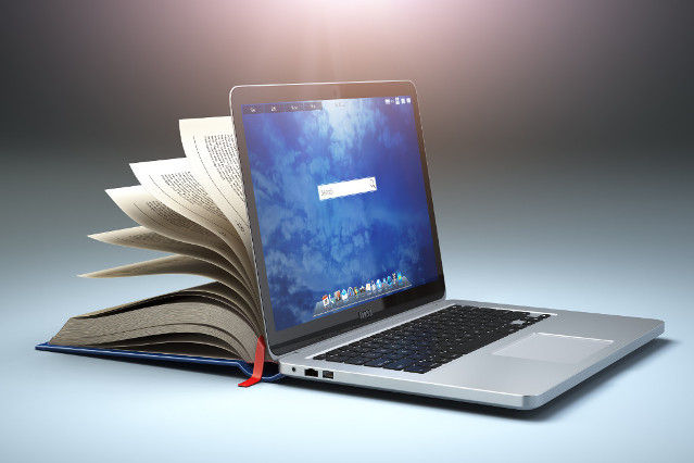 ein Laptop und ein Buch sind Rücken an Rücken aufgeklappt (Quelle: ©Bet-Noire via Getty Images ) ein Laptop und ein Buch sind Rücken an Rücken aufgeklappt