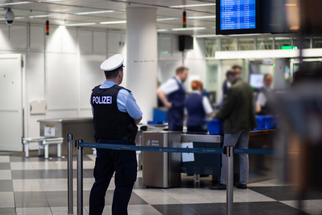 ein Bundespolizist steht an einer Gepäckkontrolle am  Flughafen