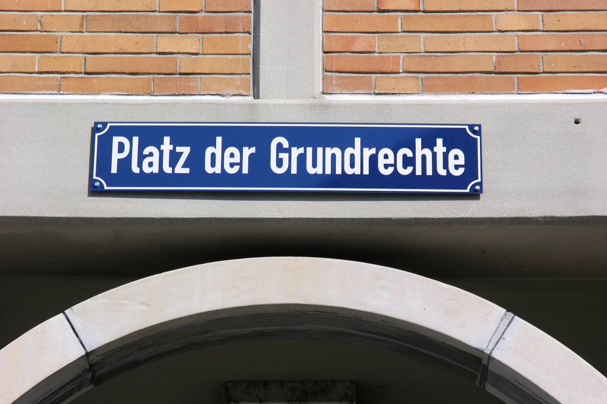 verweist auf: Beratung der Regierung und des Bundestages im Bereich Sicherheit (Quelle: © Jürgen Fälchle - stock.adobe.com) an einer Mauer ist ein Schild mit der Beschriftung Platz der Grundrechte angebracht (verweist auf: Beratung der Regierung und des Bundestages im Bereich Sicherheit) (Bild hat eine Langbeschreibung)