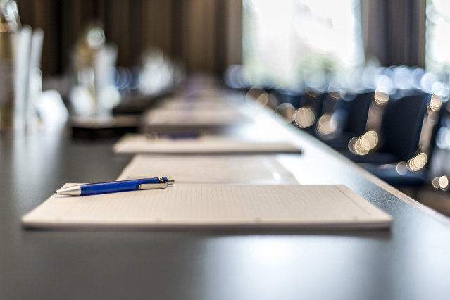 conference table with pads and pens on it