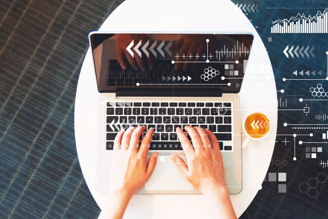 Top view of a laptop with hands on the keyboard