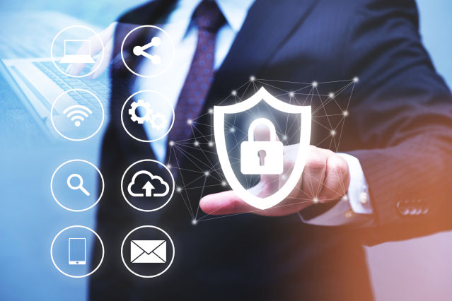 A man taps a virtual shield with lock and next to it are shown various digital symbols (Source: Kiyoshi Hijiki via Getty Images) A man taps a virtual shield with lock and next to it are shown various digital symbols