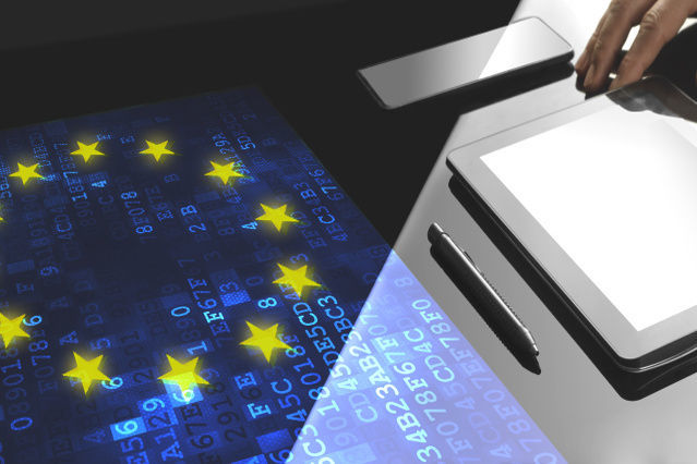 there is a tablet and pen in front of a screen with the EU flag (Source: ©denizbayram - stock.adobe.com) there is a tablet and pen in front of a screen with the EU flag